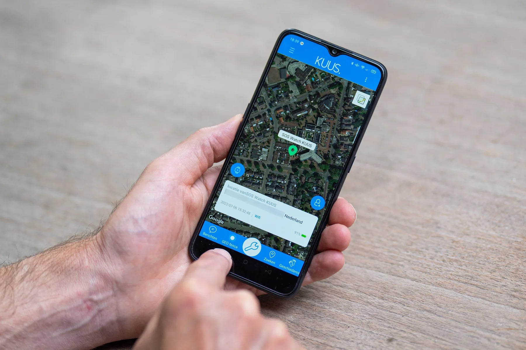 Hand met een telefoon waarop de locatie in de KUUS app te zien is